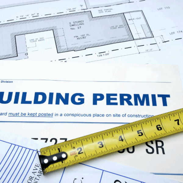 close up of commercial construction permits with measuring tape