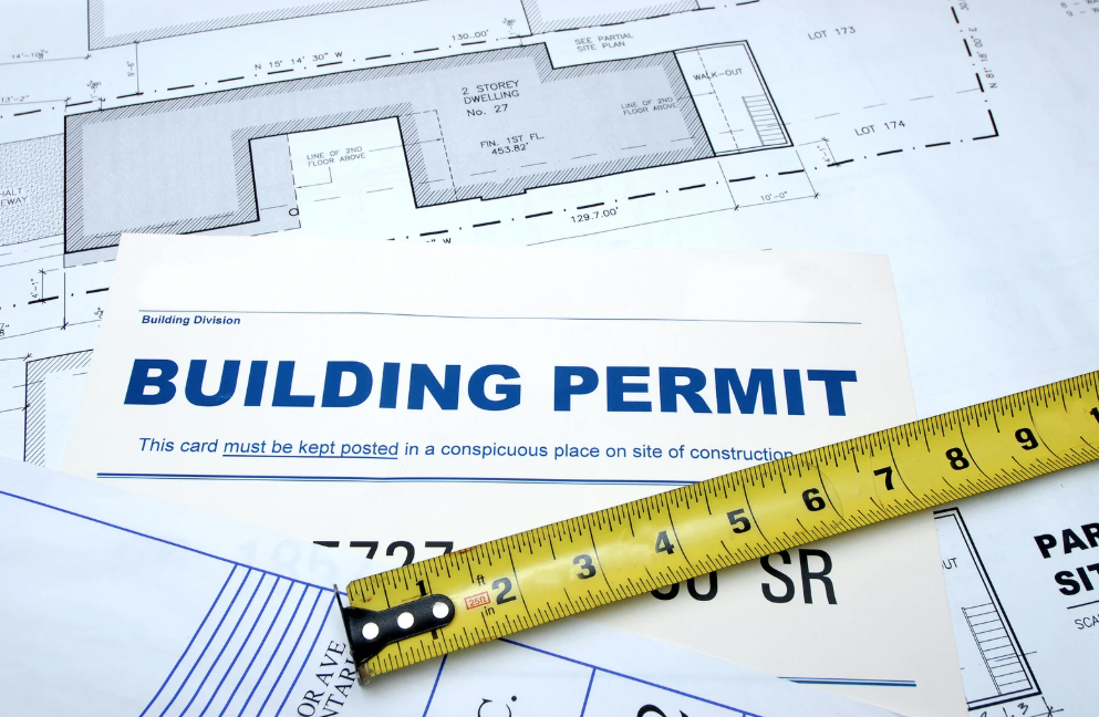 close up of commercial construction permits with measuring tape